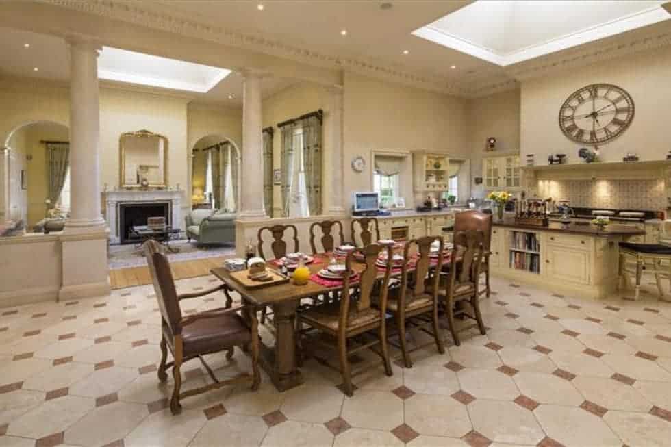 这是宽敞的厨房，米黄色的墙壁和天花板与墙壁上的橱柜相匹配。有足够的空间放一个大的木制餐桌作为早餐区。图片来自Toptenrealestatedeals.com。