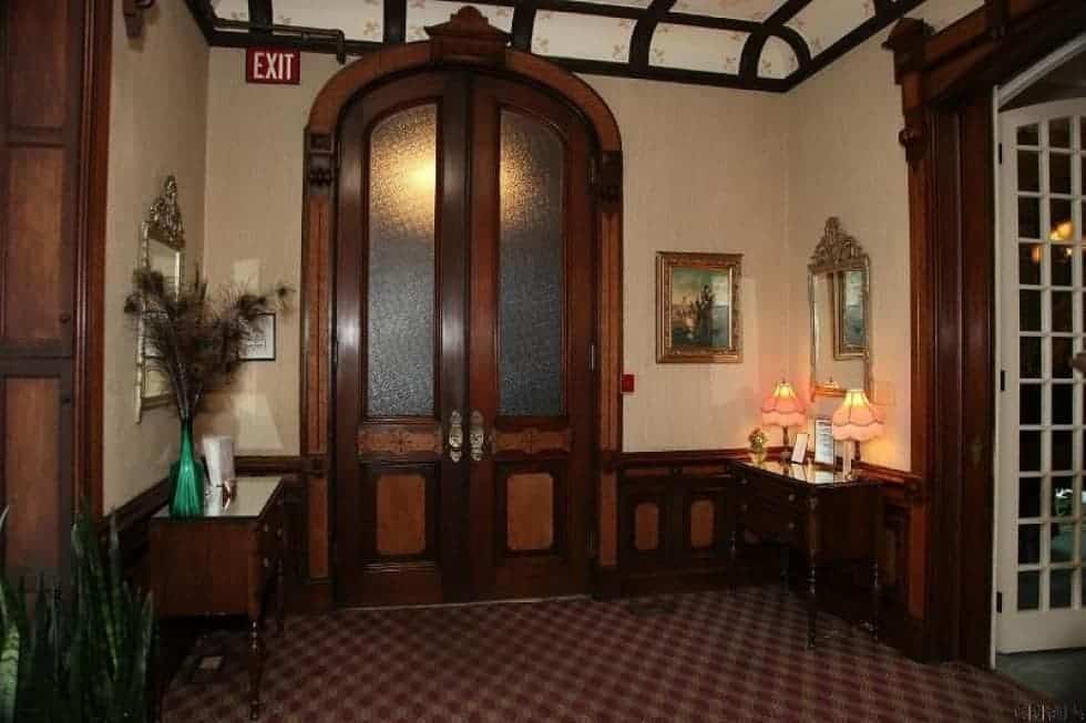 进入房屋后，迎接你的是这个门厅，它有一个带有玻璃板的深色木制拱形正门。这个框架与模具和控制台桌融合得很好。图片来自Toptenrealestatedeals.com。