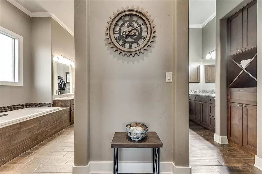一个圆形齿轮挂钟固定在木桌上方，装饰着主浴室。