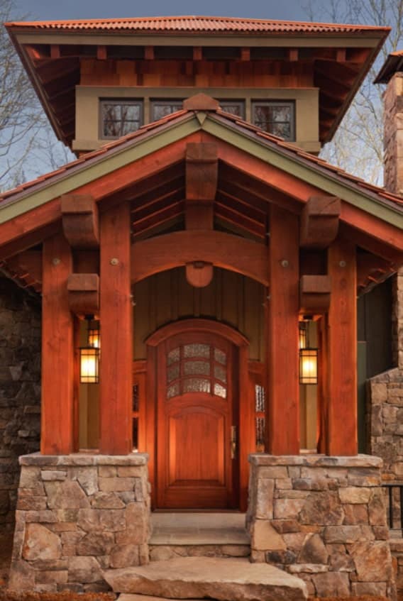 住宅入口有双柱和拱形前门，温暖的玻璃烛台照明良好。