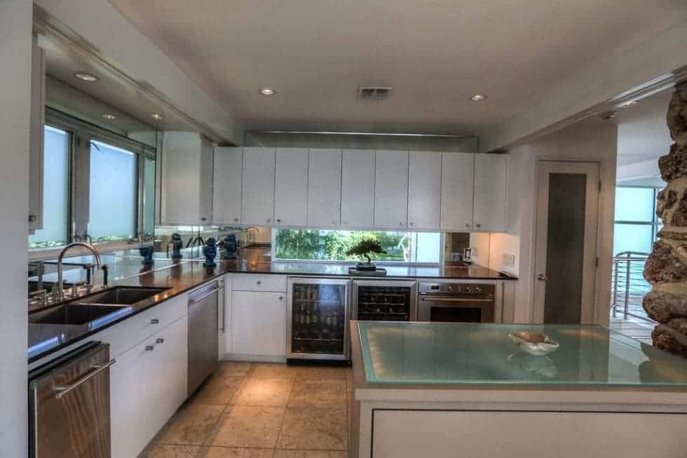 这是厨房的半岛的白色橱柜与衬砌墙。这些补充的玻璃墙和电器。图片由Toptenrealestatedeals.com。