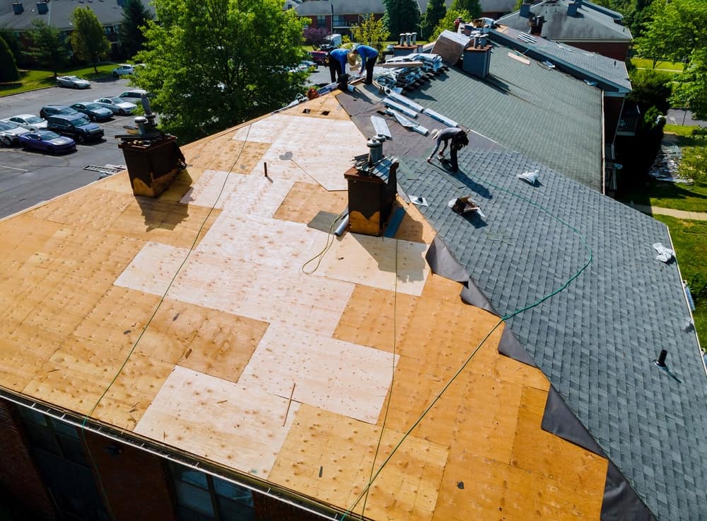 一群正在修理屋顶的工人的鸟瞰图。