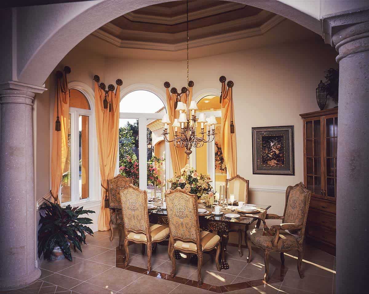 正式餐厅优雅的椅子,手工雕刻的木质餐桌,拱形窗户,一个华丽的吊灯挂在天花板的一步。
