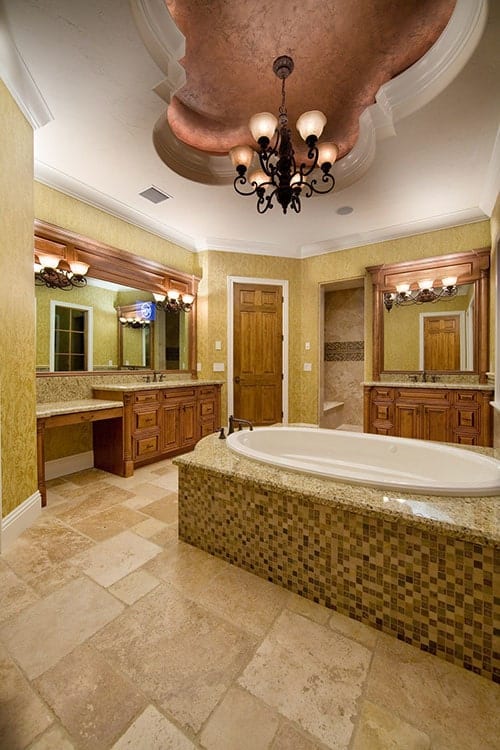 主浴室配备了木制梳妆台、一个深泡浴缸和一盏悬挂在托盘天花板上的华丽吊灯。
