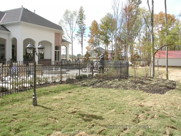 后外景显示广阔的草坪和锻铁围栏围绕着房子。
