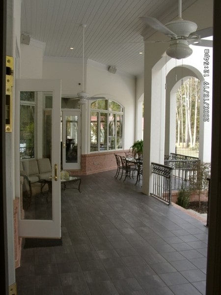 带顶棚的门廊铺有瓷砖地板，白色镶板天花板，还有多个休息区。