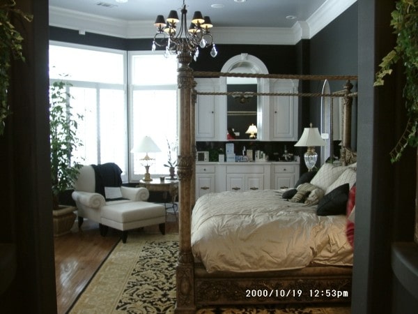 主卧室有一张天篷床，白色的梳妆台，舒适的躺椅休息室靠飘窗。