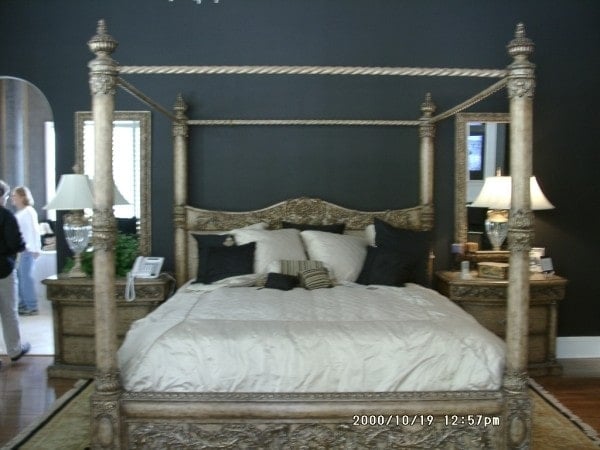 配套的床头柜和台灯旁边的雕花木冠床。