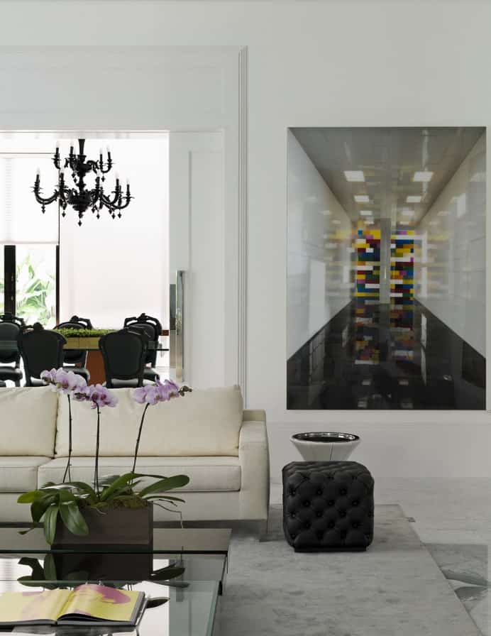 客厅的这张视图展示了另一张沙发的黑色簇绒茶几，它位于通往用餐区的拱门旁。