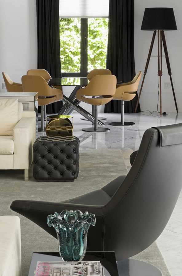 沙发一侧的黑色皮革转椅与黑色皮革簇绒边桌相匹配。