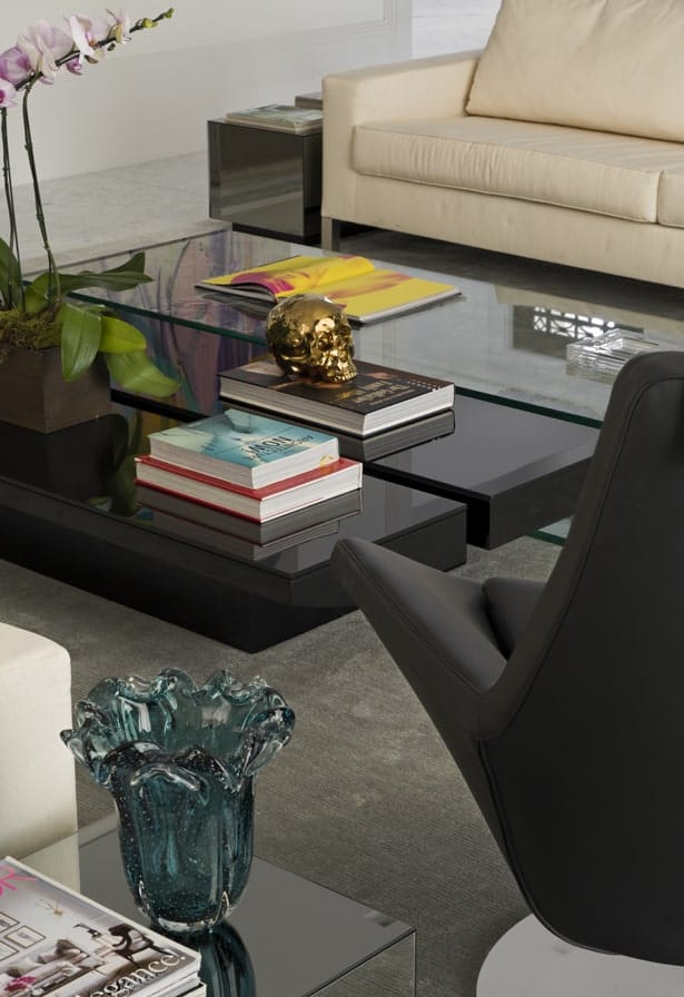 近距离观察玻璃咖啡桌，可以看出它独特的设计，黑色的一半与灰色的地毯形成鲜明对比。