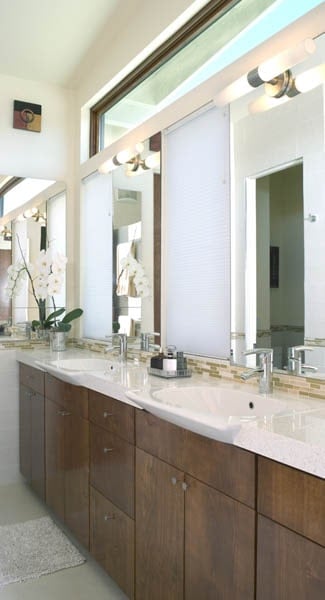 主浴室有双洗手台，卫生间在无框镜子中反映。