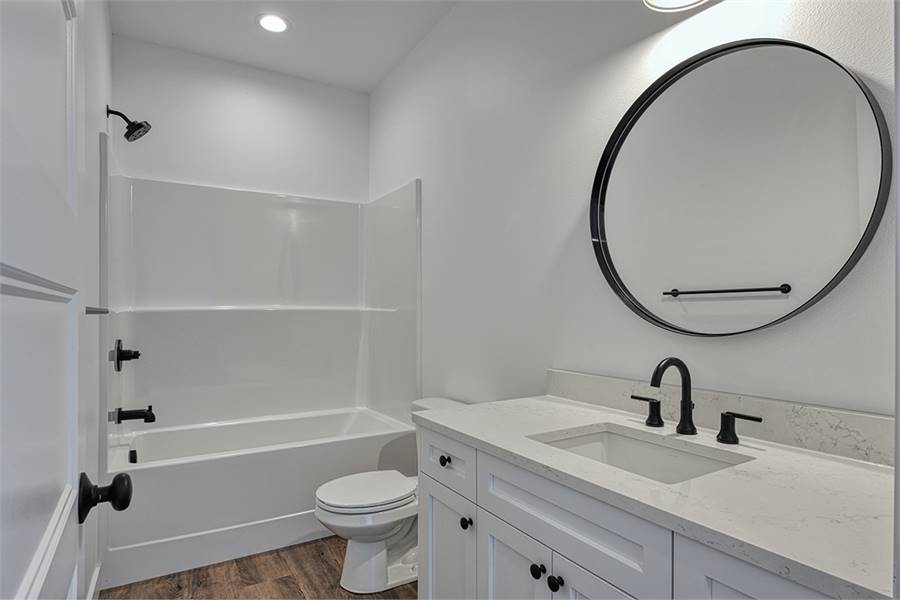 这间浴室配有白色梳妆台、马桶、淋浴和浴缸。