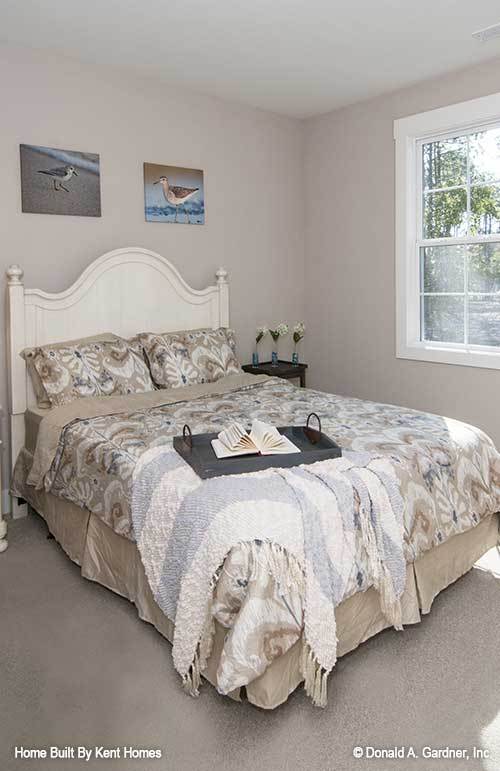 这间卧室的特色是一张白色的裙子床，上面有可爱的艺术品。