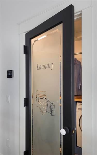 洗衣房被一扇玻璃门包围，门上镶有黑色镶边。