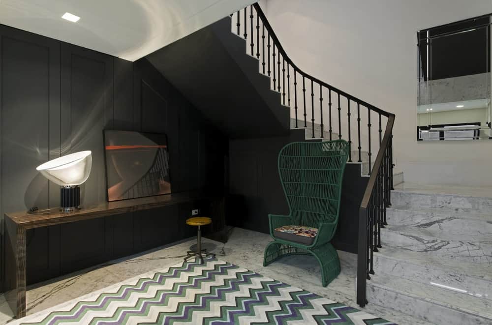 这是地下室一层的门厅，有一把装饰性的椅子，在黑色墙壁的映衬下格外显眼。