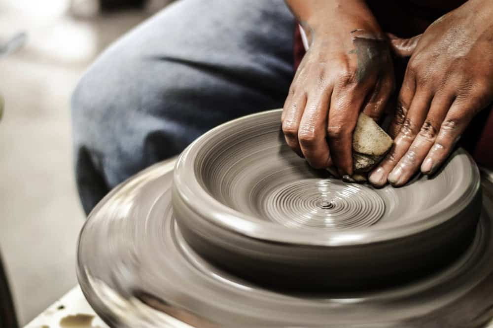 在制陶轮上制作陶器的人。