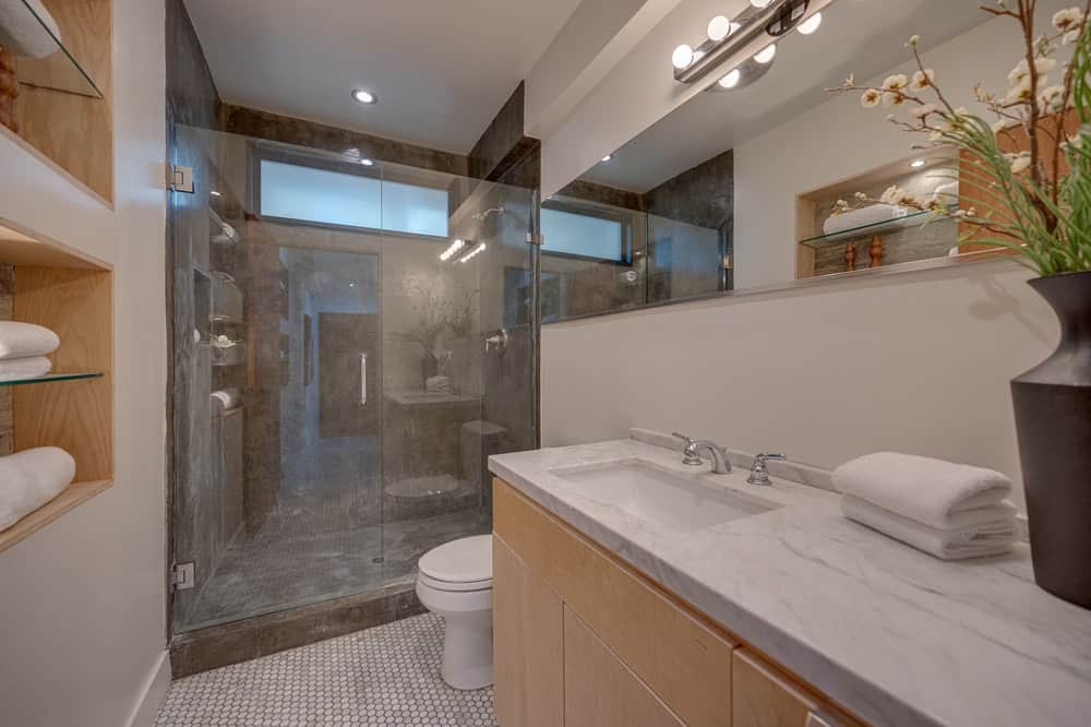另一个卧室有一个玻璃淋浴区另一边的白瓷厕所。图片由Toptenrealestatedeals.com。