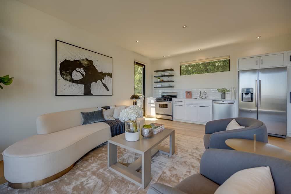 这是客厅,米色沙发相匹配的墙壁、天花板和咖啡桌面积地毯。图片由Toptenrealestatedeals.com。