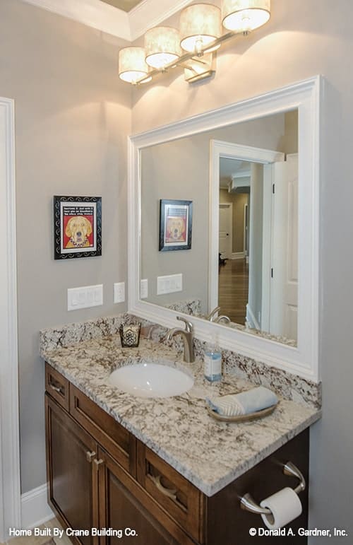 浴室设有一个木制梳妆台和一面白色大镜框镜子。