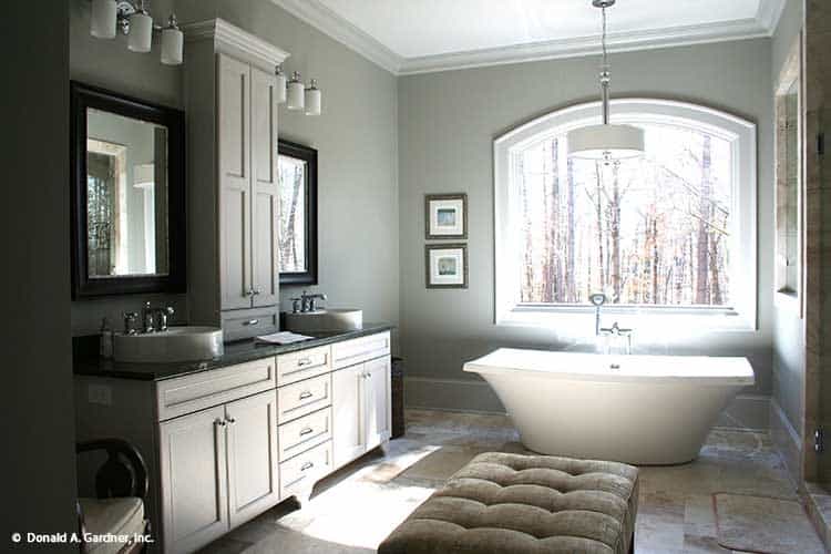 主浴室设有双洗手池梳妆台和拱形窗户下的独立浴缸。