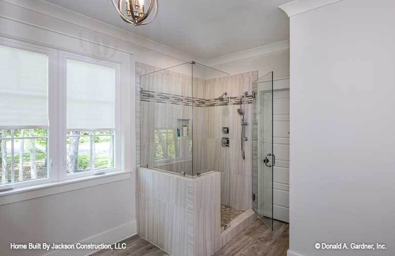 主浴室设有步入式淋浴，瓷砖墙壁，铬固定装置，和玻璃铰链门。