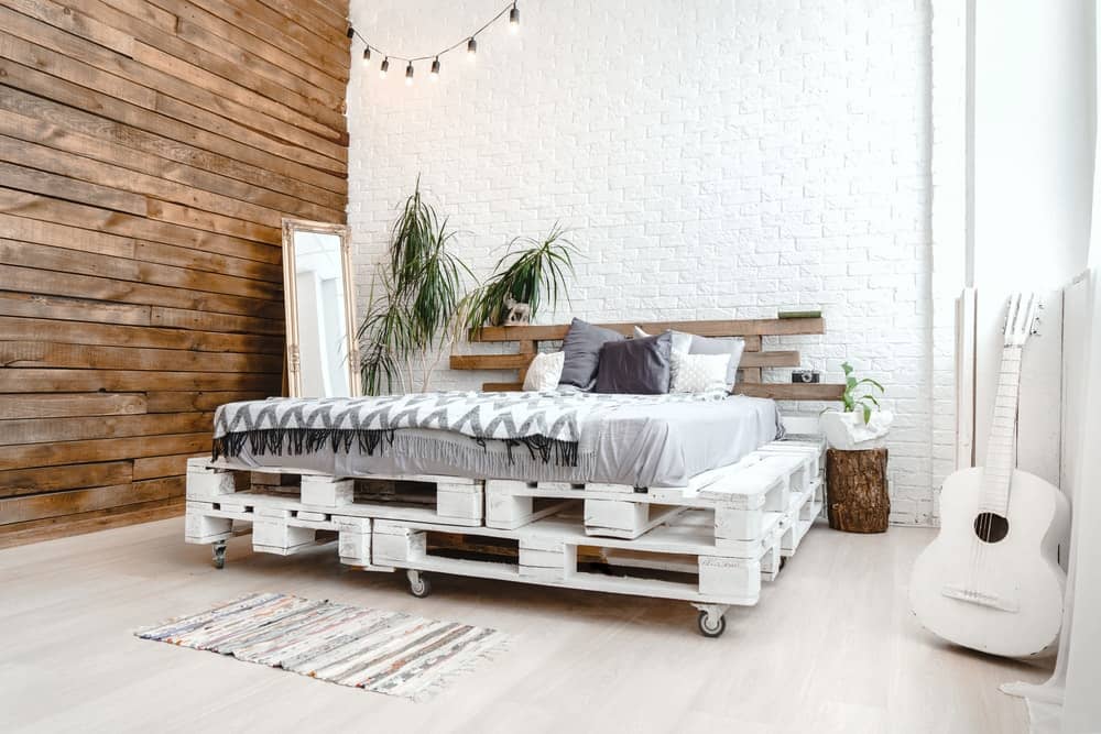 这间卧室里有一张用木托盘做成的质朴木床架。