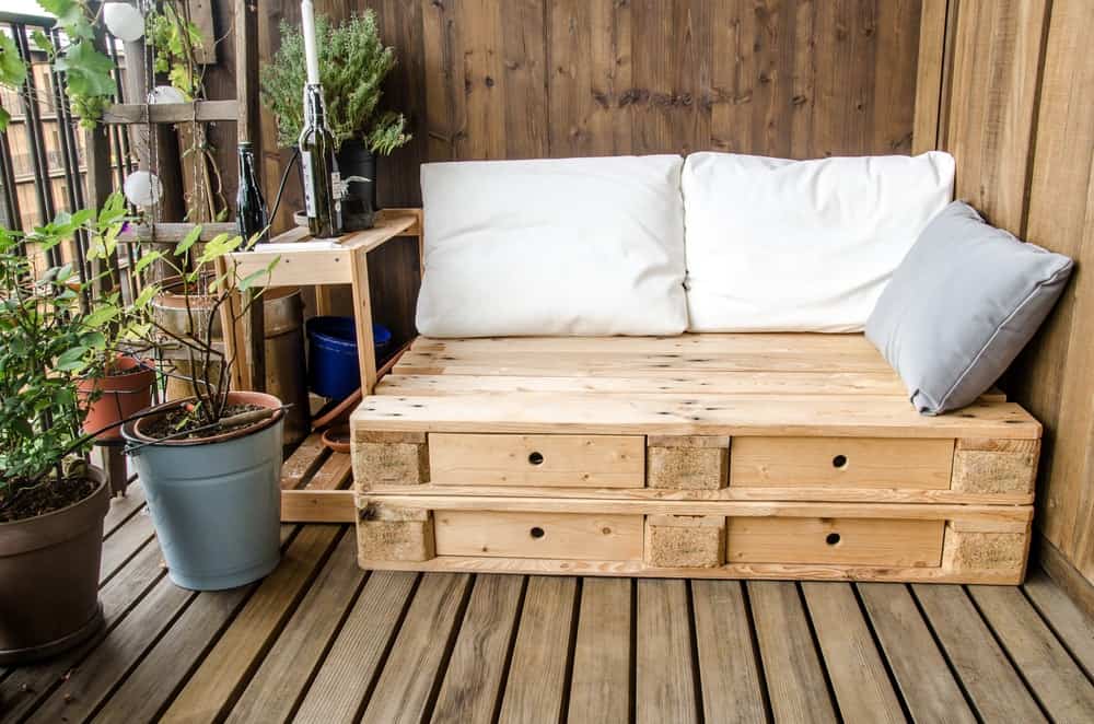 这是一个木质甲板露台，有一个由木托盘制成的木质长凳。