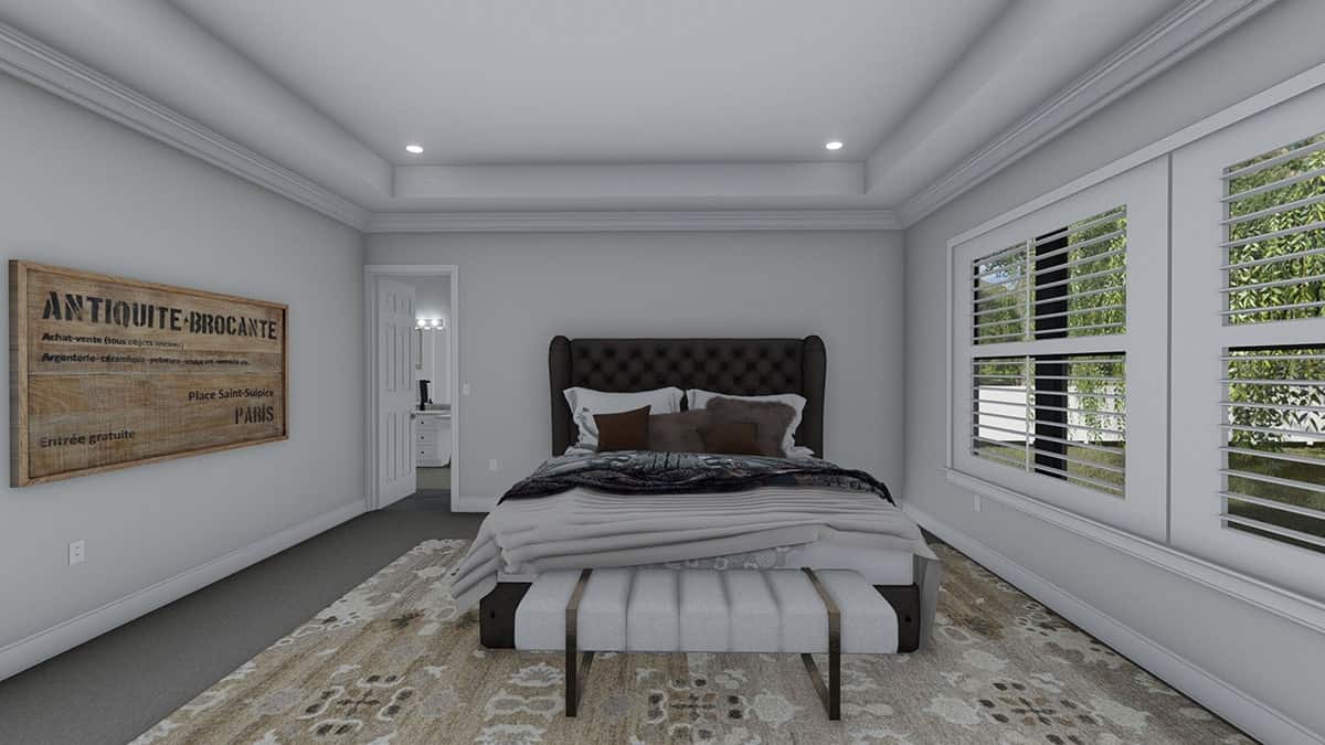 主卧室里有一张簇绒翼背床和一张舒适的长凳，上面放着有图案的区域地毯。
