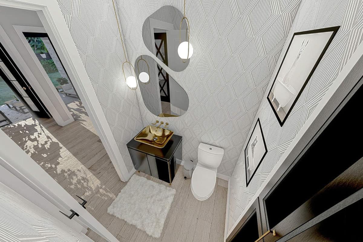 盥洗室与一个马桶和一个水槽虚荣辅以独特的镜子和黄铜吊坠。