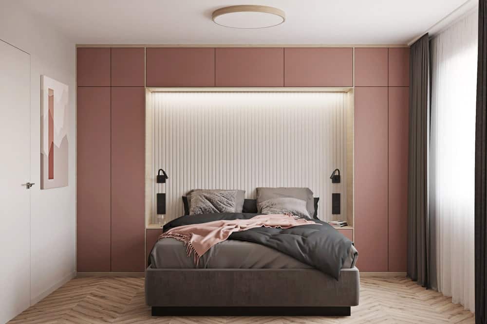 另一间卧室有一面泥土色的玫瑰镶板墙，用作大床的床头板，床上有一个内置凹室，内有现代化的照明设备。