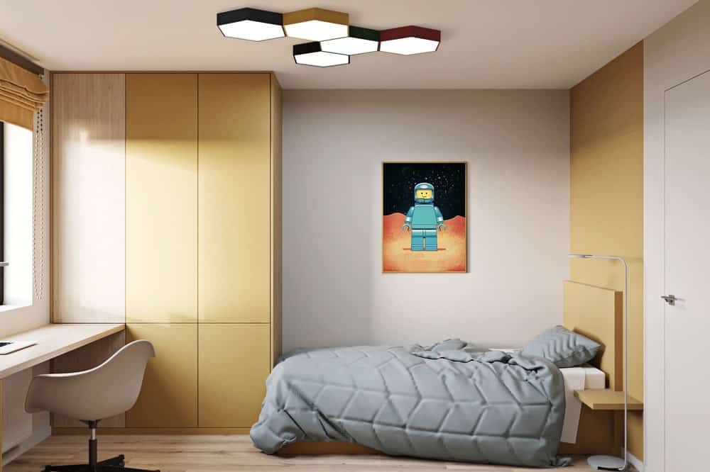 这是整个卧室的另一个视角，一张灰色的床，木制的嵌壁式结构和一幅彩色的壁挂式艺术品，增添了一些色彩。