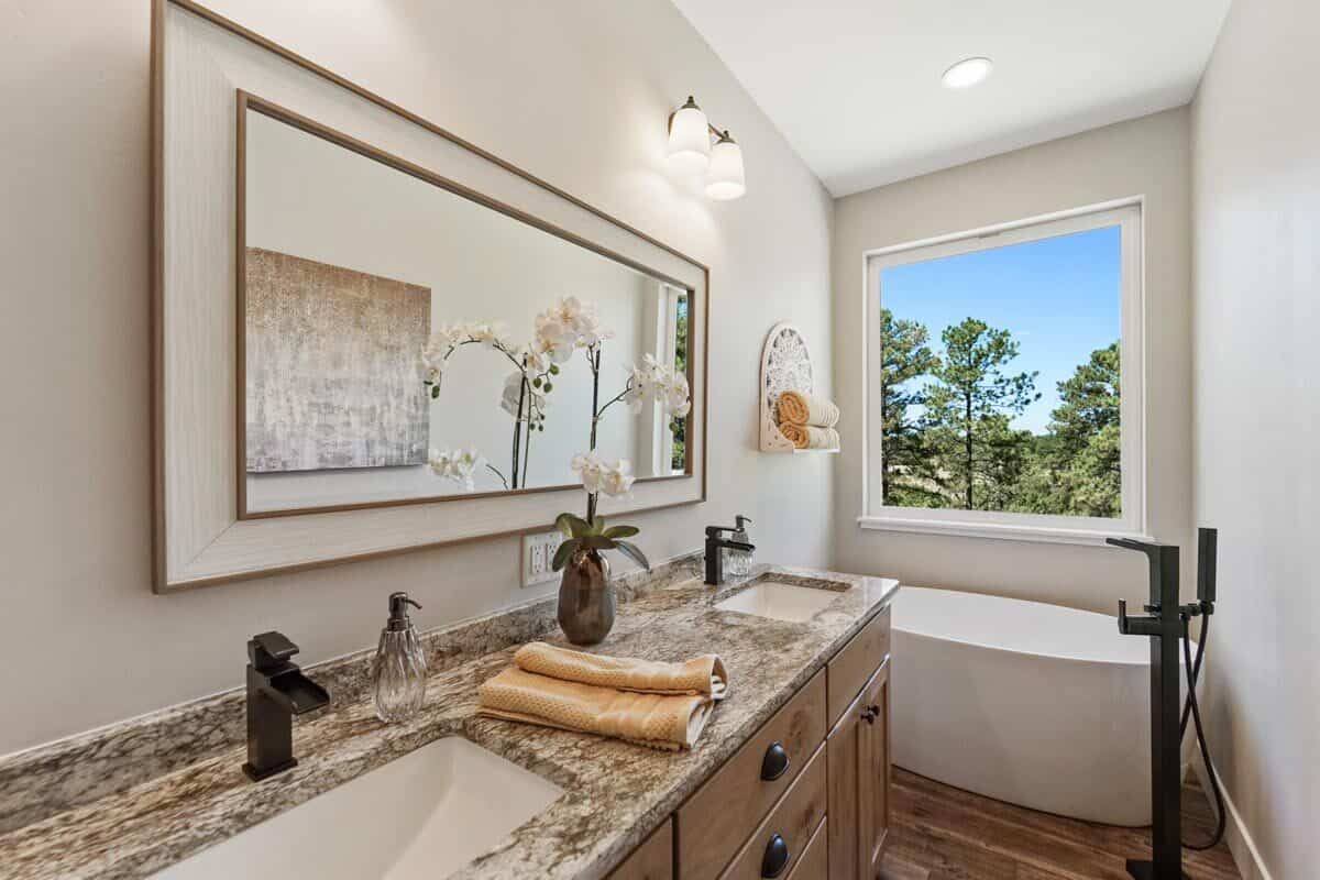 主浴室有一个双洗手池梳妆台和一个独立的浴缸，放置在落地窗下。