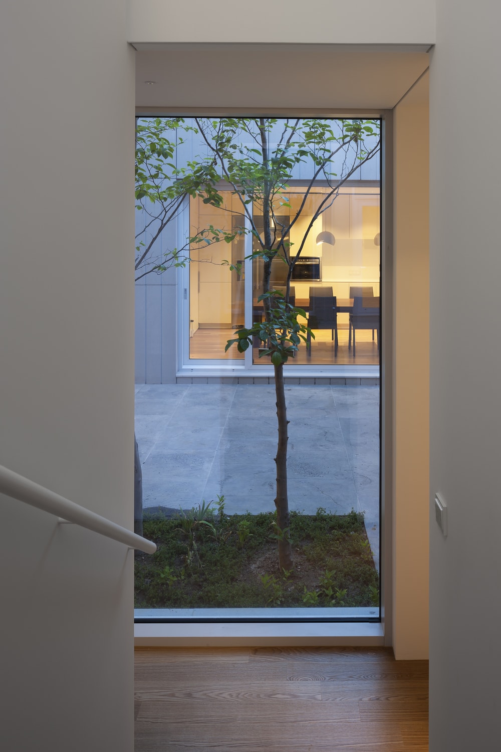 这是一个从内部楼梯到庭院的有利位置，通过玻璃墙到用餐区。