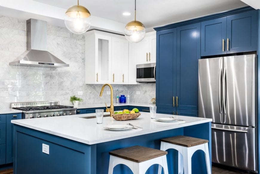 这是对厨房岛台的近距离观察，它有蓝色的橱柜和厨房岛台，与白色的台面和搭配天花板的白色凳子形成对比。