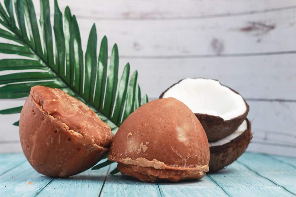 从椰子中提取糖，加入一半椰子和叶子，放在木板桌上。