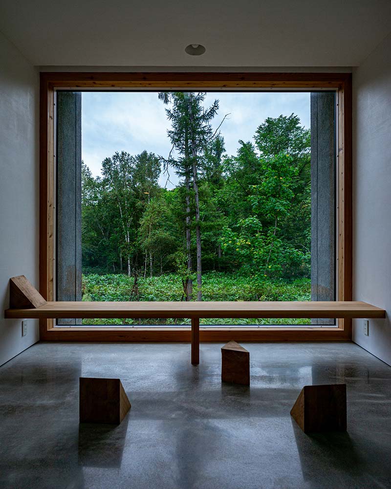其中一面玻璃墙的内部安装了一个面向景观的内置木凳。