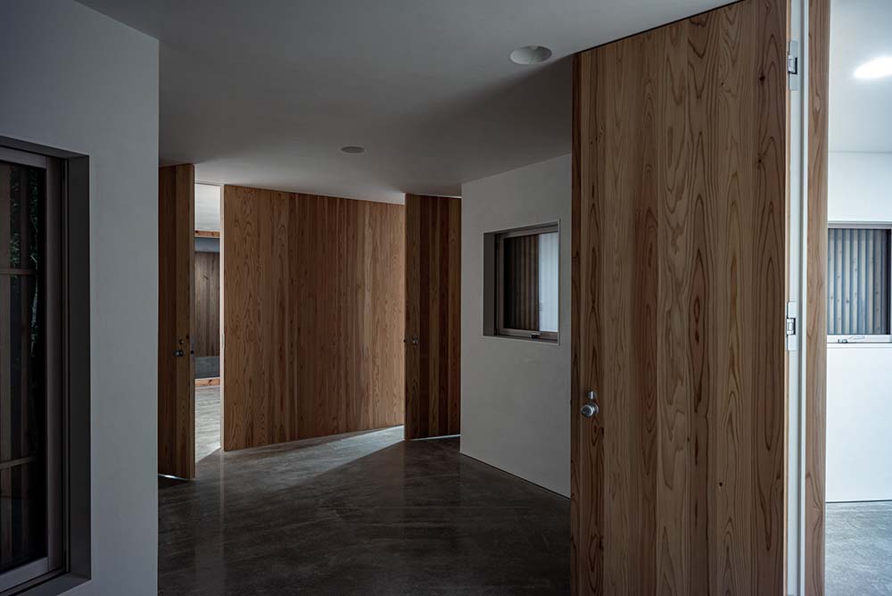 这是房子走廊的另一个视图，展示了明亮的白色墙壁，辅以各种木制元素。