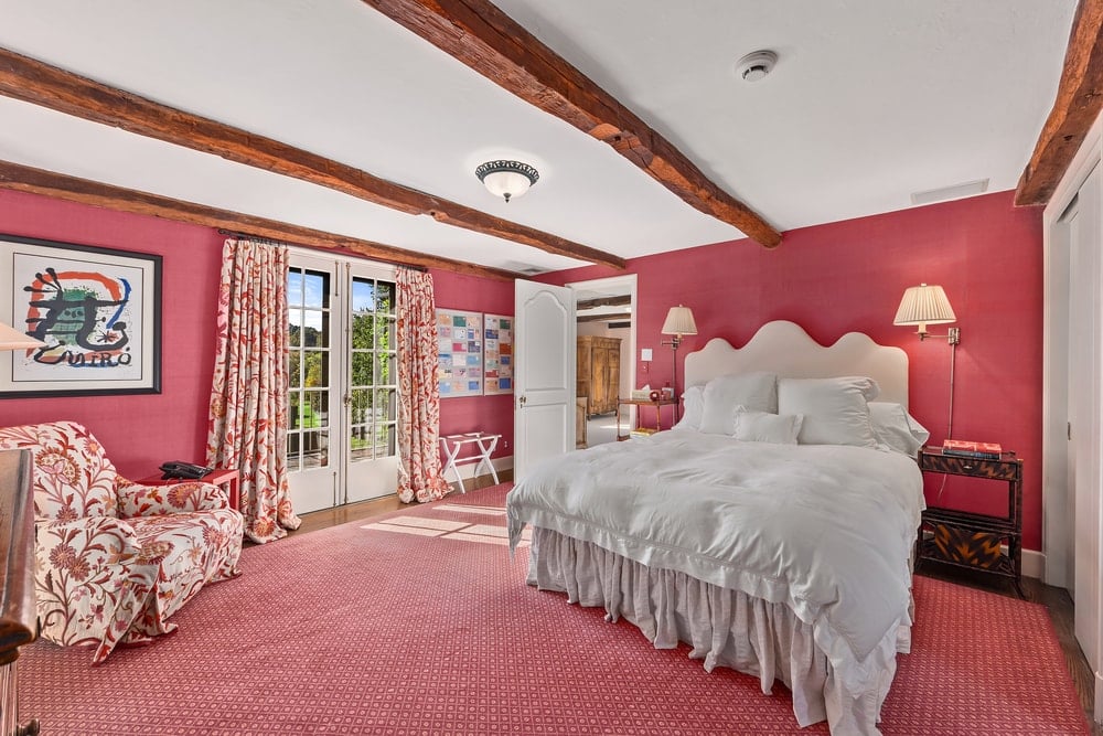 这间卧室的地板和墙壁上有一致的淡粉色调，使床与带横梁的白色天花板一起脱颖而出。图片来自Toptenrealestatedeals.com。
