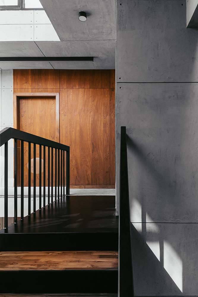 这是一个近距离观察楼梯的顶部平台，通往一堵带有相同色调木门的木墙。