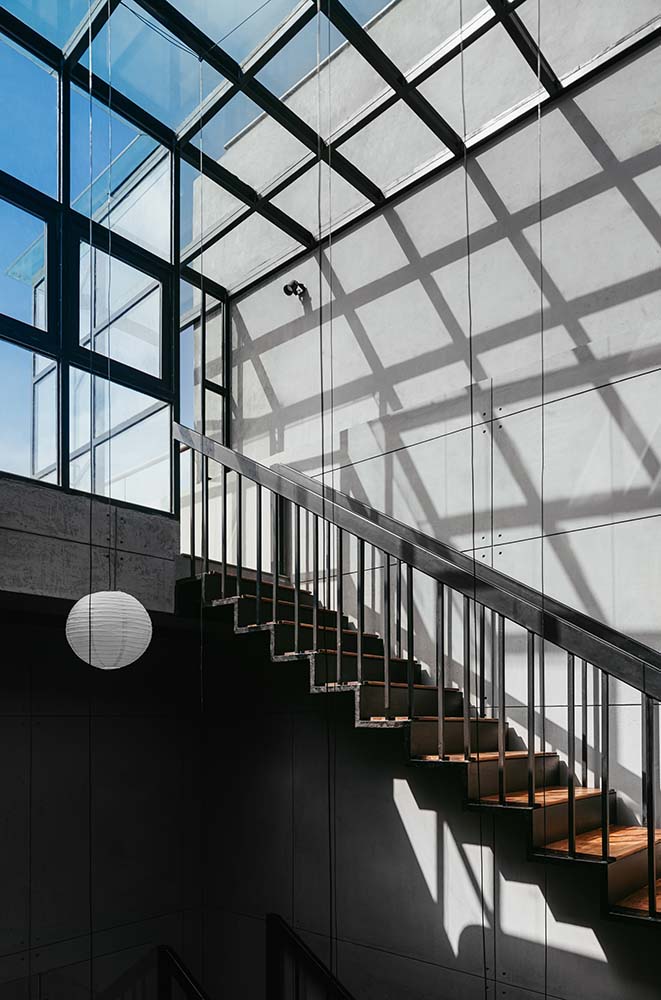 这是楼梯的顶部，通往玻璃墙，玻璃门顶部有一个大的玻璃天花板。