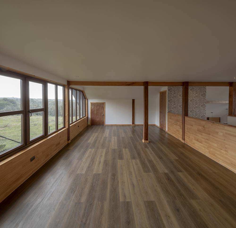 这是另一个宽敞明亮的房间，深色硬木地板与拱形天花板形成对比。