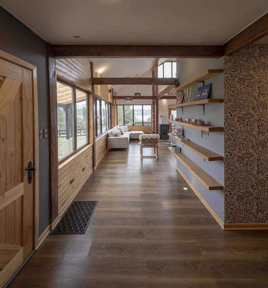 一进入房子，你就会受到这个简单的门厅的欢迎，门厅里有一扇木门和一个带浮动木架子的大柱子。