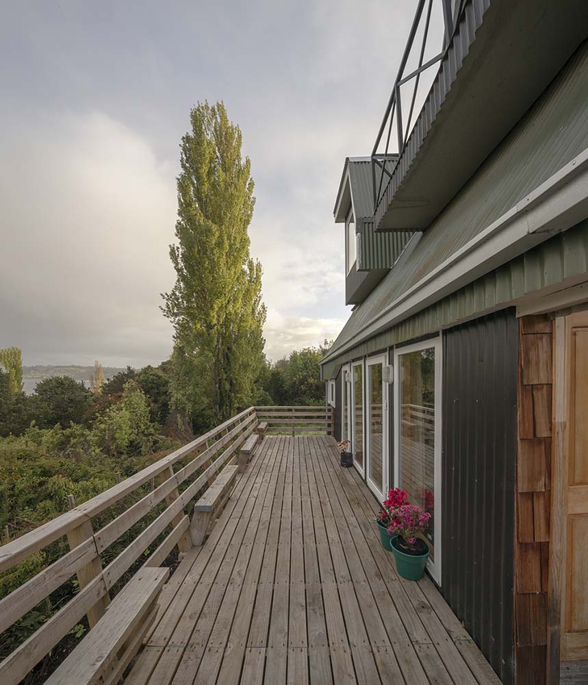 这是房子的大阳台露台，有木制的船板地板，与木栏杆相匹配。
