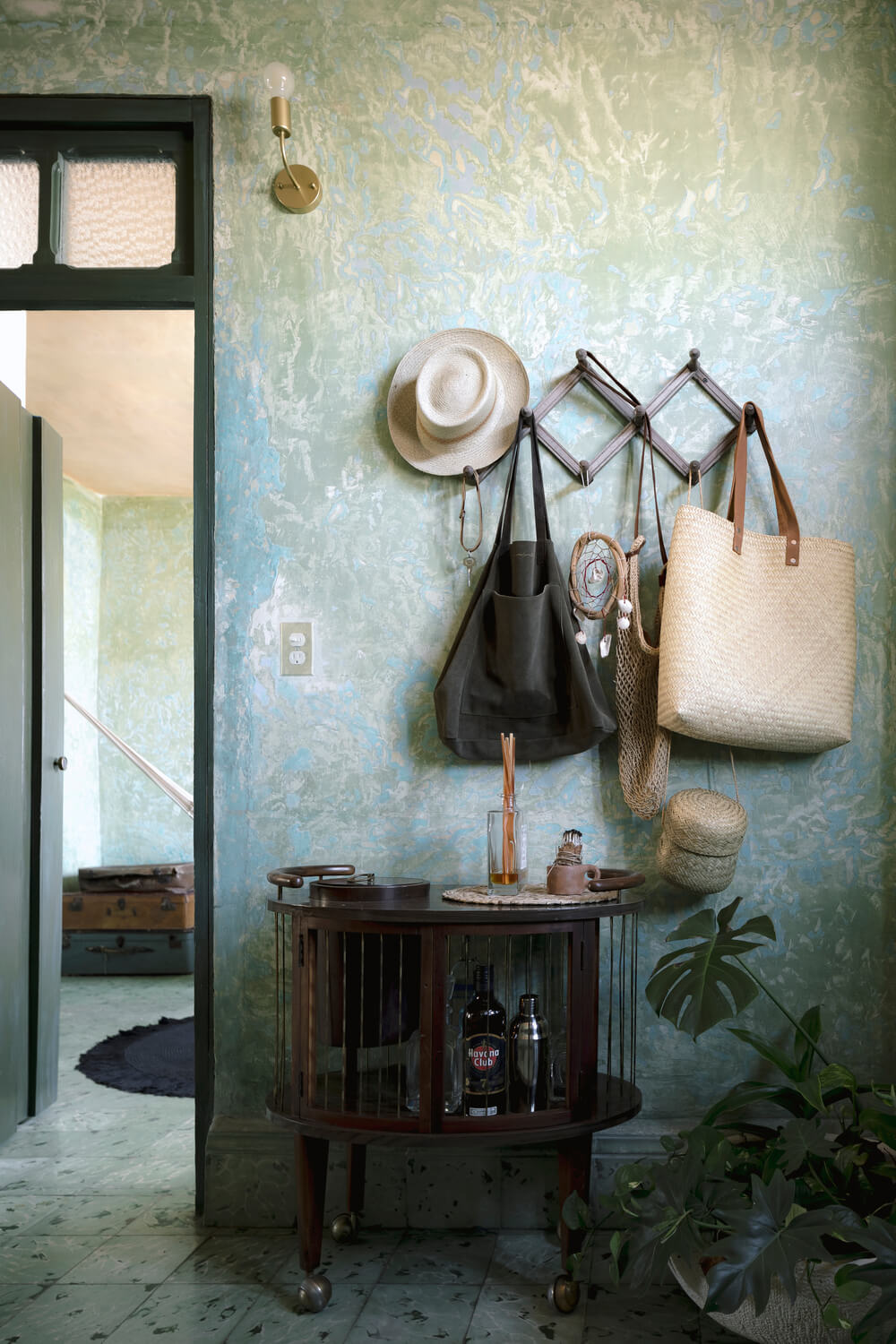 一进入房子，你就会受到这个简单的门厅的欢迎，门厅里有一个齐腰高的书柜，上面有一组用来挂袋子和帽子的钩子。
