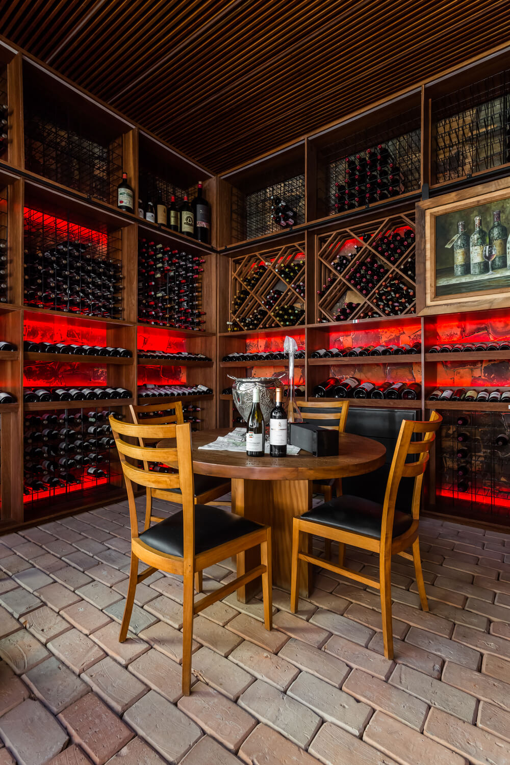 酒窖里有一套木制餐厅，是一个品酒区，周围是内置的葡萄酒架。