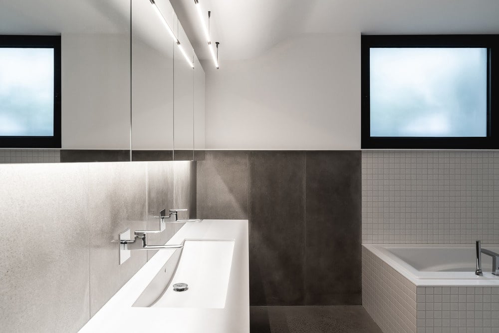 这黑暗其他浴室瓷砖的下半部分白墙形成对比的水槽,墙壁和浴缸。