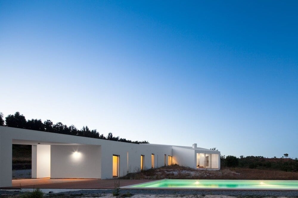 这是房子后面的一个视图，展示了房子的温暖的光芒和游泳池的空灵的光芒。