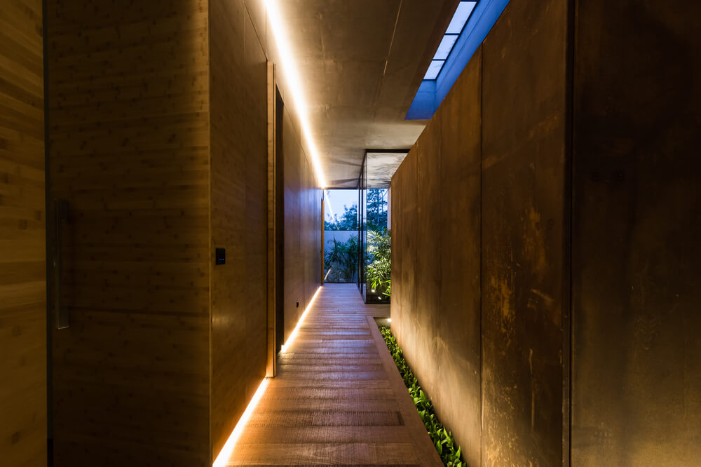 这是一个有木墙、木地板、现代温暖照明和天窗的走廊。