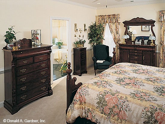 主卧室有地毯地板，深色木家具，和一个类似温泉的套间。